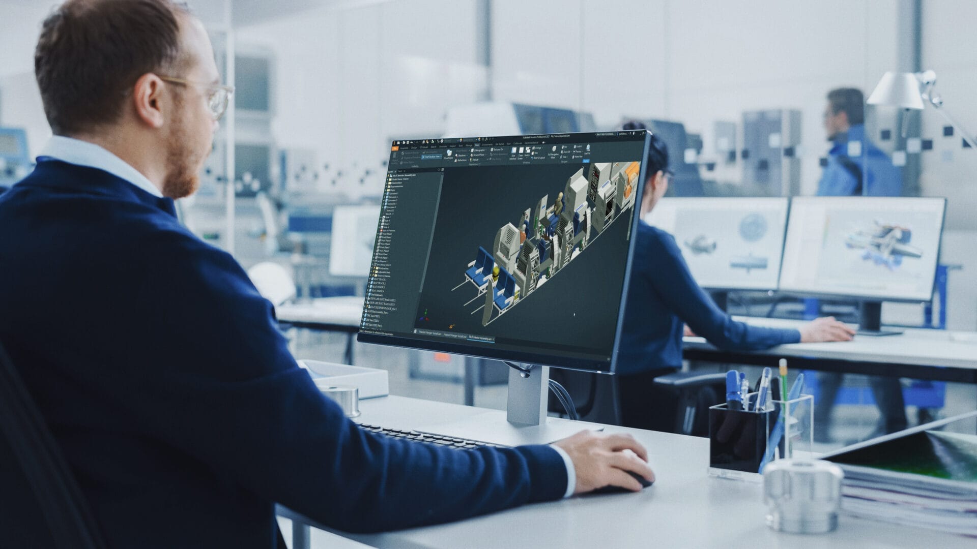 un hombre utiliza un ordenador para editar un modelo CAD del interior de un avión