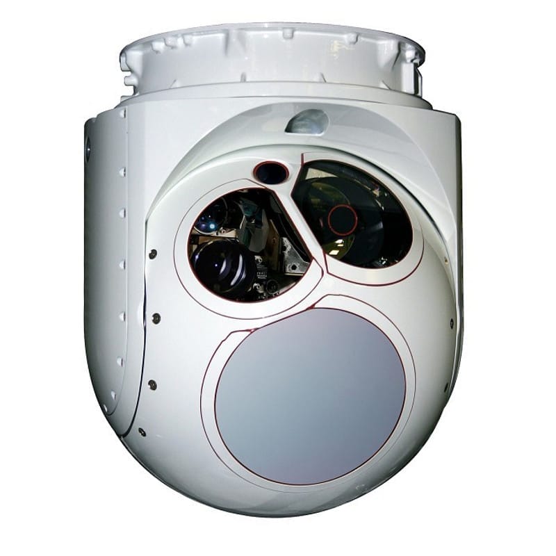 Primer plano de una torreta electroóptica esférica de color blanco, equipada con múltiples lentes y sensores, que actúa como un potente multiplicador de capacidad para tareas de vigilancia o reconocimiento en aviones o drones.