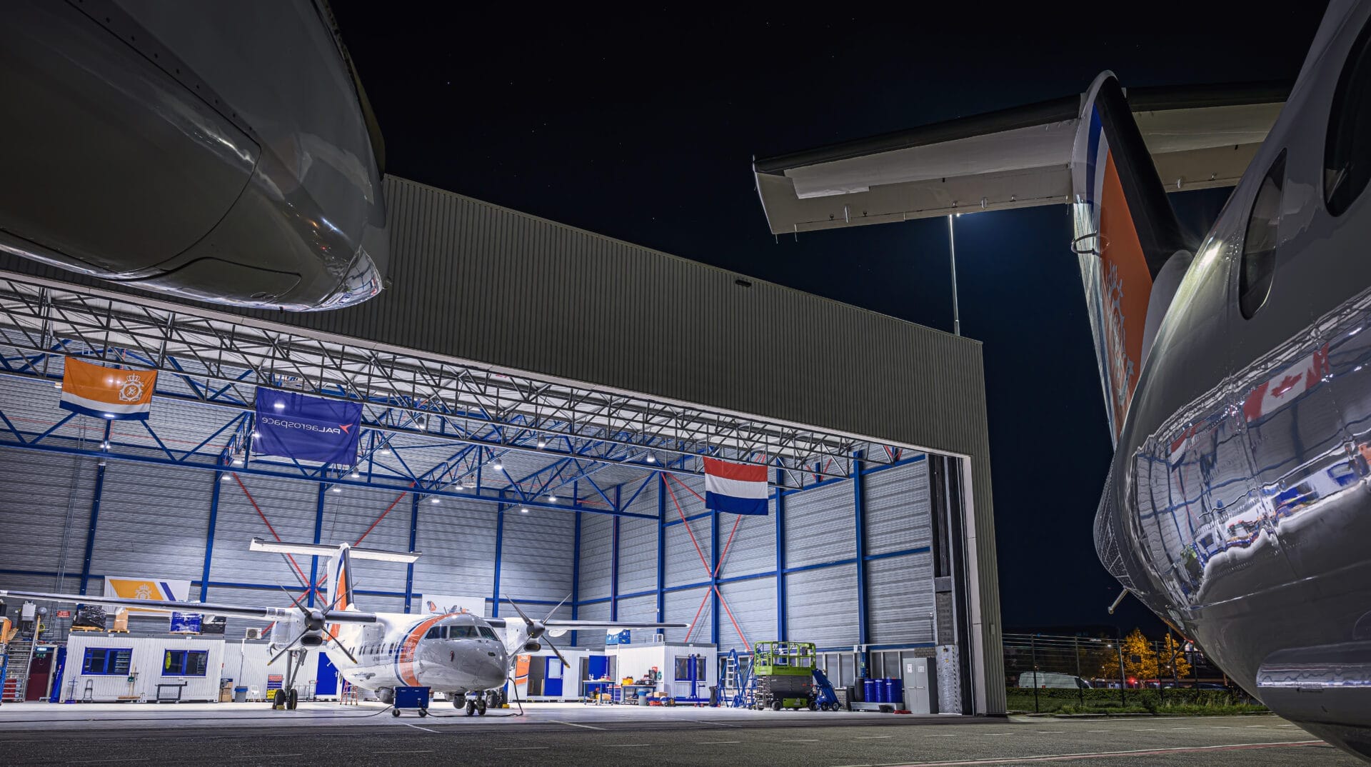 Zdjęcie hangaru holenderskiej straży przybrzeżnej mieszczącego samolot nadzoru morskiego Pal Aerospace Dash 8 w Schiphol