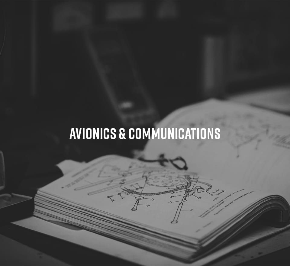 An open technical manual displaying diagrams of avionics equipment sits on a desk, highlighting Avionics & Communications—essential components in Aerospace Engineering.